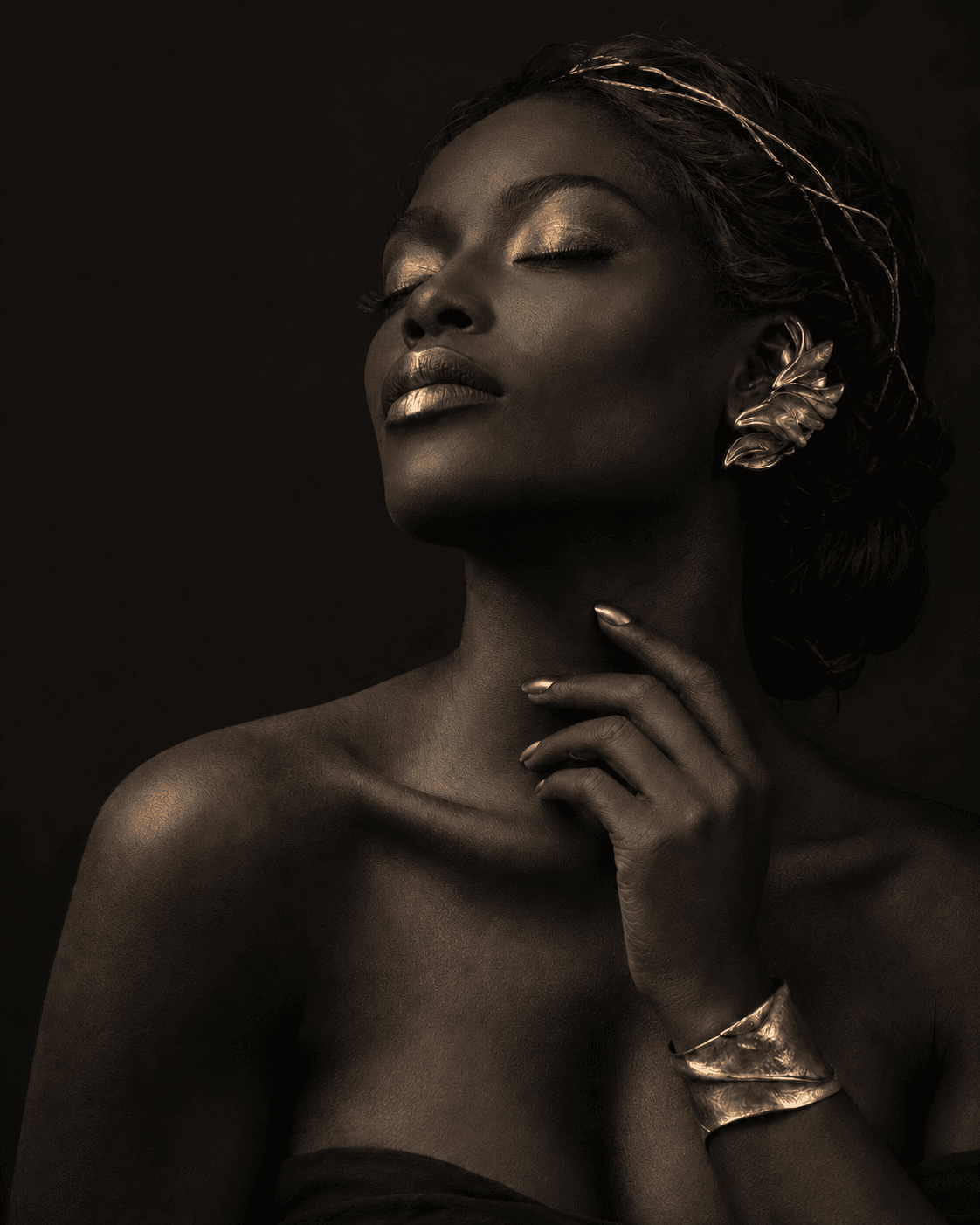 Retrato artístico en negro con uñas, maquillaje y joyas doradas